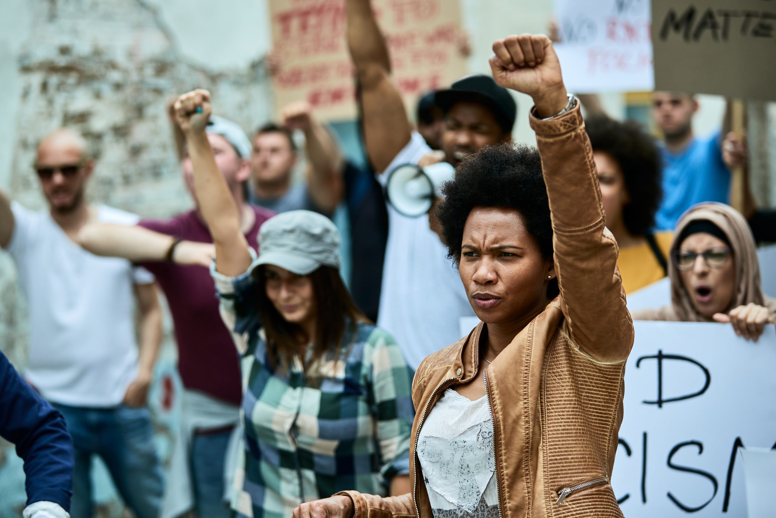 People with arms up in the air holding signs