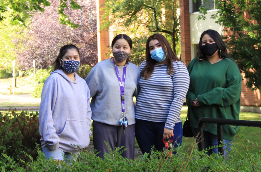 Students-smiling-outside-of-the-dorms-wearing-masks Students smiling outside of the dorms wearing masks