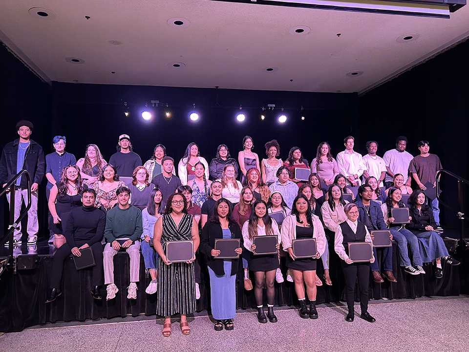 students standing on a stage smiling