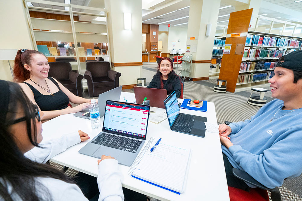WOU students sitting at a table in the library