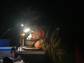 Photo of student researcher working by flashlight.
