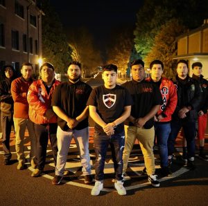 The Omega Delta Phi members posing together outside at night.