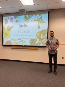 Justin Sunada holding award in front of projector.