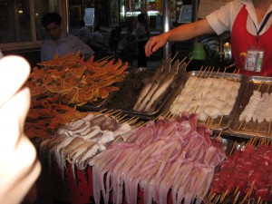 A food vendor with lots of possible foods to attempt. Of the foods pictured here we only tried the shark and squid (or octopus).